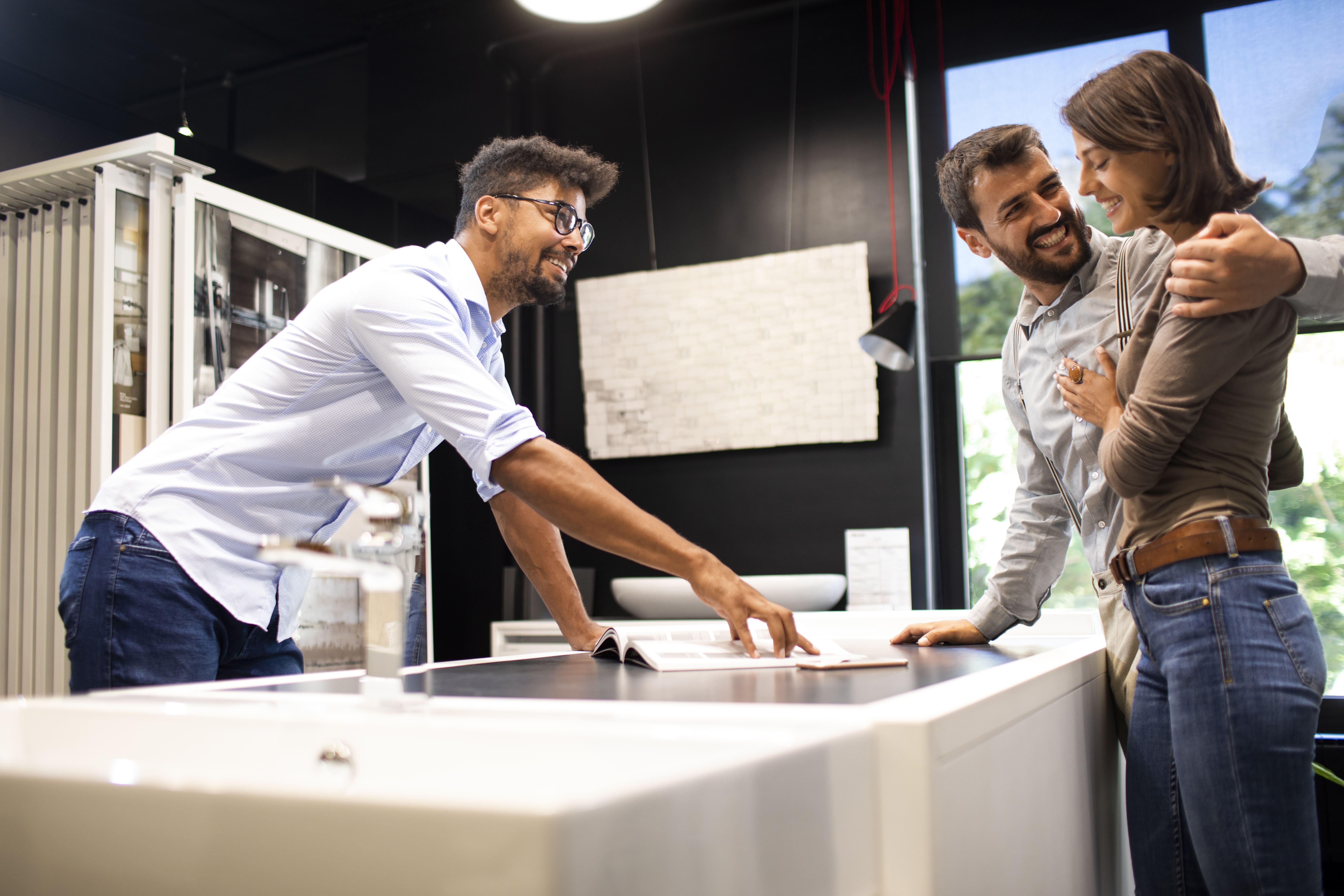 A couple examines a catalog on a kitchen counter